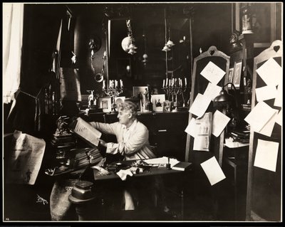 David Belasco in his study, leafing through a dictionary, 1909 by Byron Company
